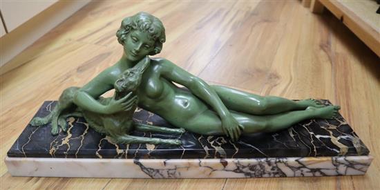 An Art Deco green patinated bronze figure of a reclining lady with a dog, on marble plinth, signed L Bruns